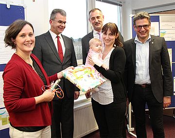 Bürgermeister Klaus Pipke (re.) gratulierte dem NBD zum fünften Geburtstag. Annette Vogel (li.) übergab ein Geschenk an Adelina, das 2.000 besuchte Baby, und seine Mutter Marina Balzer. Mit dabei Martin Herkt (2.v.l.) und Robert Gollmer (3.v.l.).