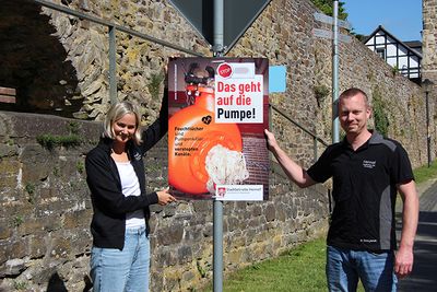 Christina Brehmer und Stefan Siebigteroth beim Aufhängen der Plakate in Hennef-Stadt Blankenberg.