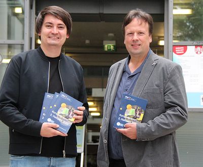 Holger Hansen, Leiter der VHS Rhein-Sieg, und Bürgermeister Mario Dahm mit dem neuen VHS Herbstprogramm.