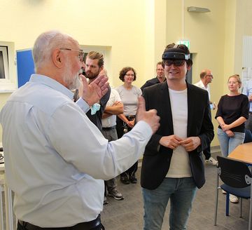 Bürgermeister Mario Dahm testet die „Augmented-Reality-Brille“. Diplom-Ingenieur  Rüdiger Heidebrecht (links) erläutert die Technik.